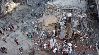 La gente inspecciona los daños en el barrio Sheikh Radwan de la ciudad de Gaza tras el bombardeo israelí del 11 de agosto.