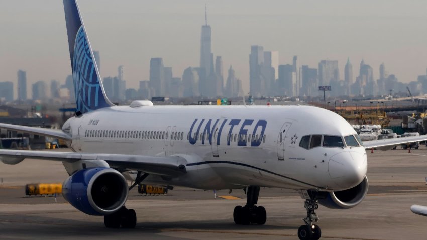 A United Airlines airplane proceeds to a runway at Newark Liberty International Airport in front of the skyline of lower Manhattan and One World Trade Center in New York City on December 4, 2024, in Newark, New Jersey. 