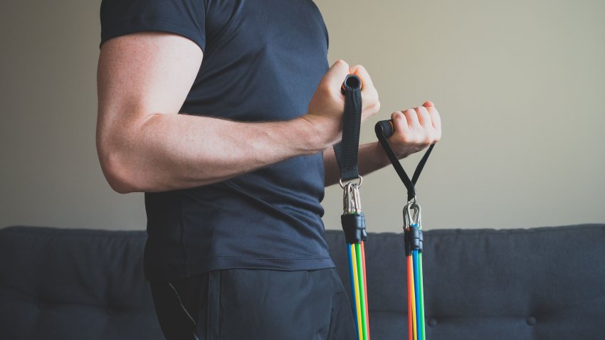 Man doing exercises with resistance bands at home.