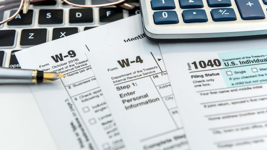 Financial time tax form with laptop and calculator. Office paperwork. Accounting