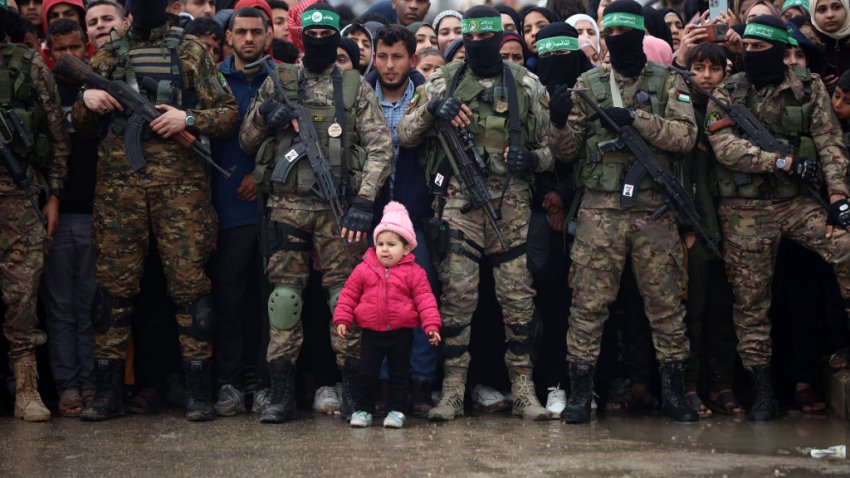 Hamas fighters gather at the site of the handing over of Israeli hostages at the Nuseirat refugee camp in the central Gaza Strip as part of the seventh hostage-prisoner release in the central Gaza Strip on February 22, 2025. Hamas’s armed wing confirms it will hand over six hostages held alive in the Gaza Strip as part of the ongoing ceasefire deal with Israel. (Photo by Majdi Fathi/NurPhoto via Getty Images)