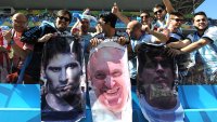 SAO PAULO, BRAZIL – JULY 01: Argentina fans display posters of Lionel Messi, Pope Francis and Diego Maradona during the 2014 FIFA World Cup Brazil Round of 16 match between Argentina and Switzerland at Arena de Sao Paulo on July 01, 2014 in Sao Paulo, Brazil.  (Photo by Chris Brunskill Ltd/Getty Images)