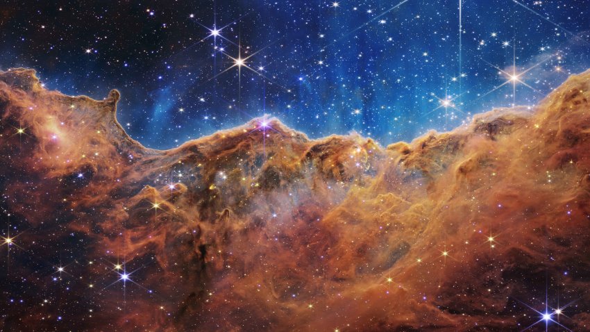 IN SPACE – JULY 12: In this handout photo provided by NASA, a landscape of mountains and valleys speckled with glittering stars is actually the edge of a nearby, young, star-forming region called NGC 3324 in the Carina Nebula, on July 12, 2022 in space. Captured in infrared light by NASA’s new James Webb Space Telescope, this image reveals for the first time previously invisible areas of star birth.  (Photo by NASA, ESA, CSA, and STScI via Getty Images)