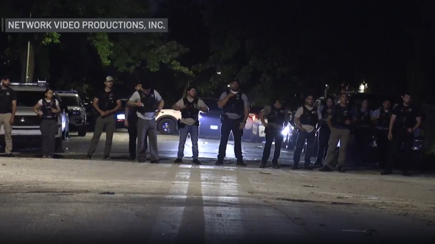 Foto de policías bloqueando una calle de noche.