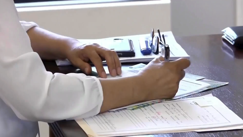Foto de una persona firmando unos documentos