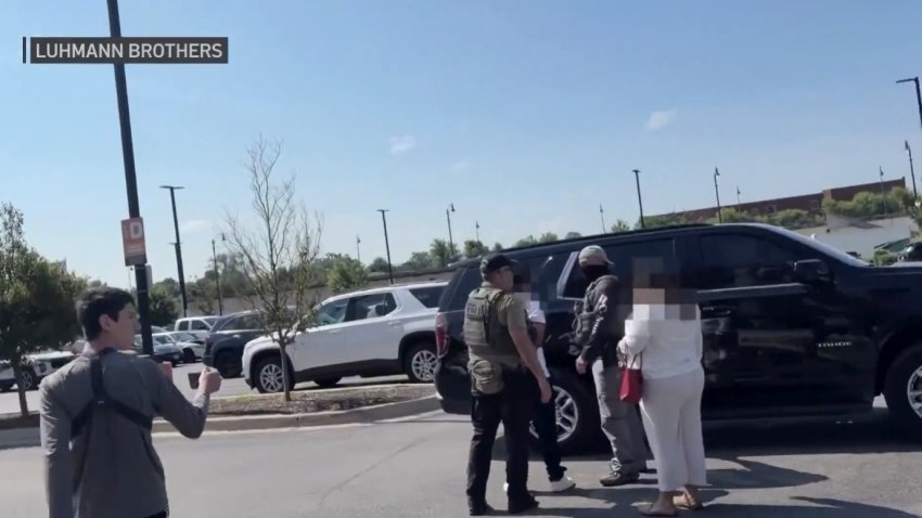Foto de arresto de agentes federales en un estacionamiento.